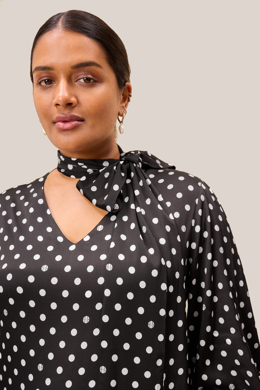Detail of Italian Dress with white polka dots on black background. Plus size THE HOUR
