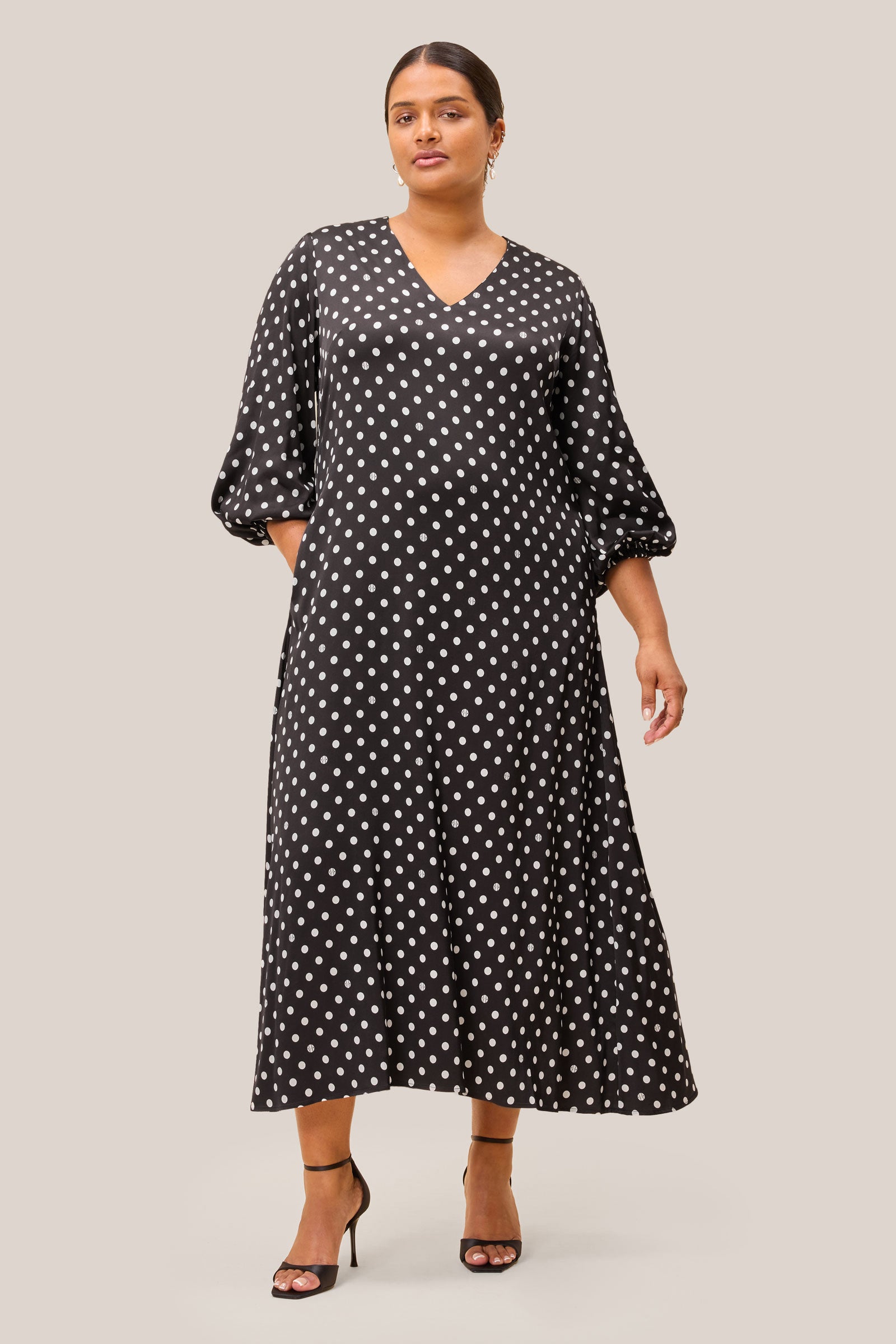 Functional side pocket detail on a black satin midi dress with polka dots. plussize THE HOUR