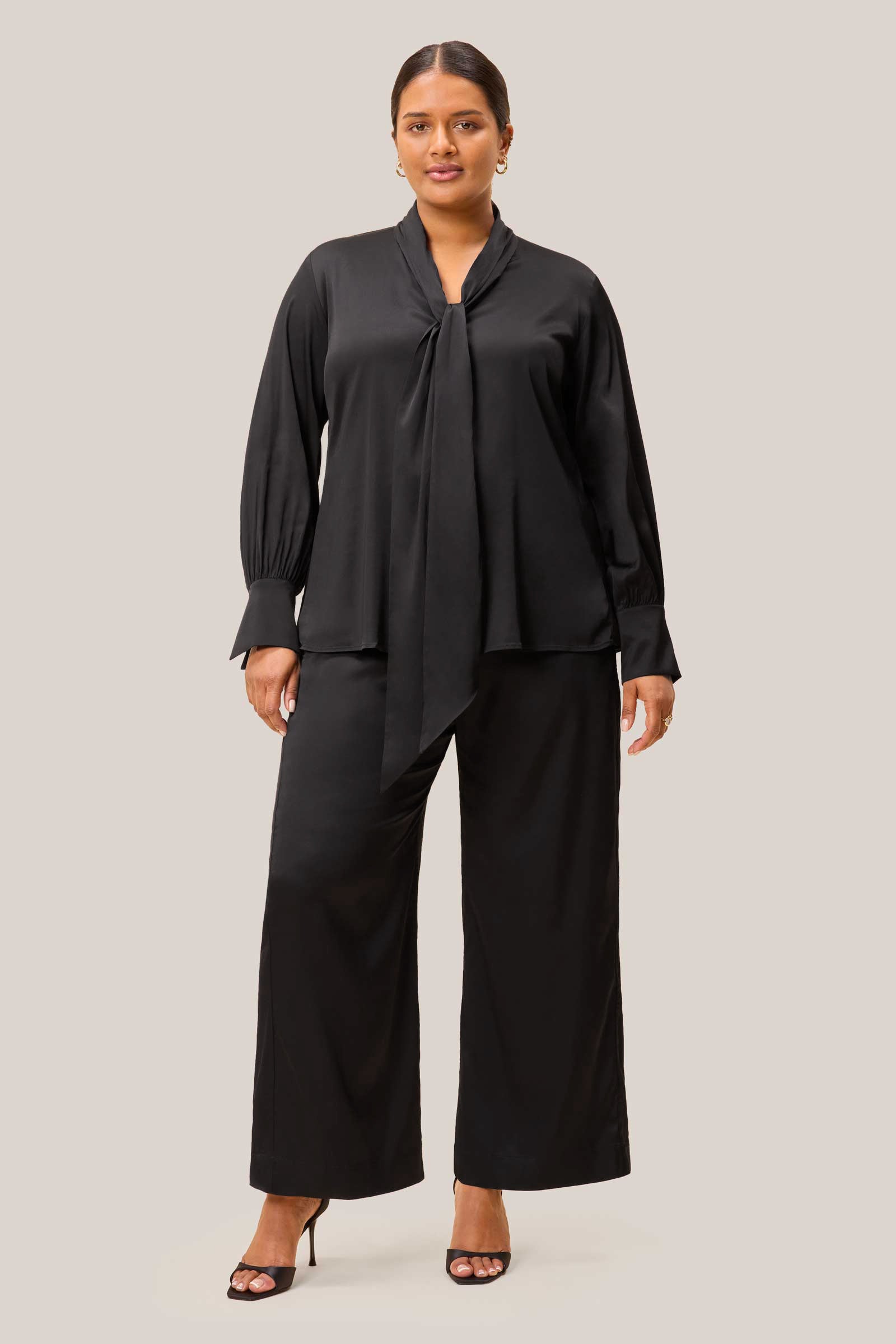 outfit: black satin bow blouse styled untucked. Plus size. The HOUR
