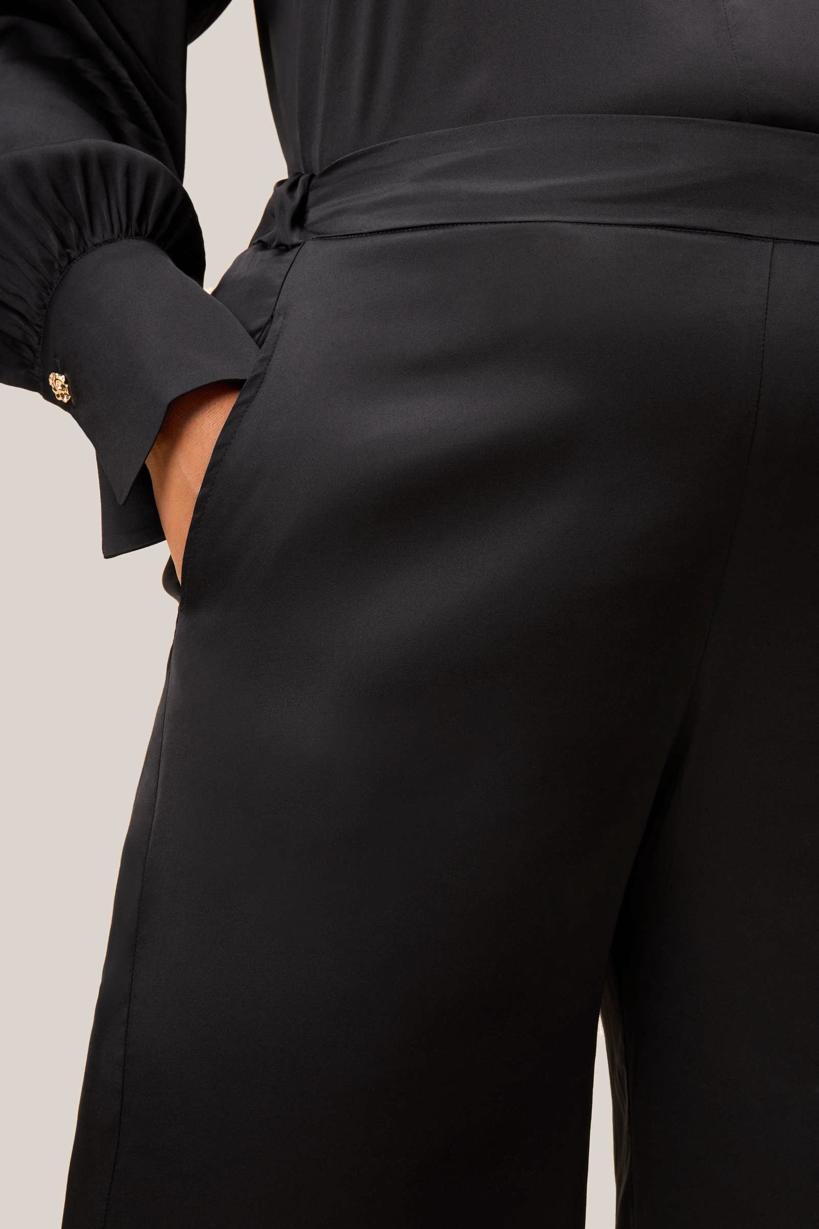 Black satin PLUS SIZE palazzo trousers. Detail of pocket and seam