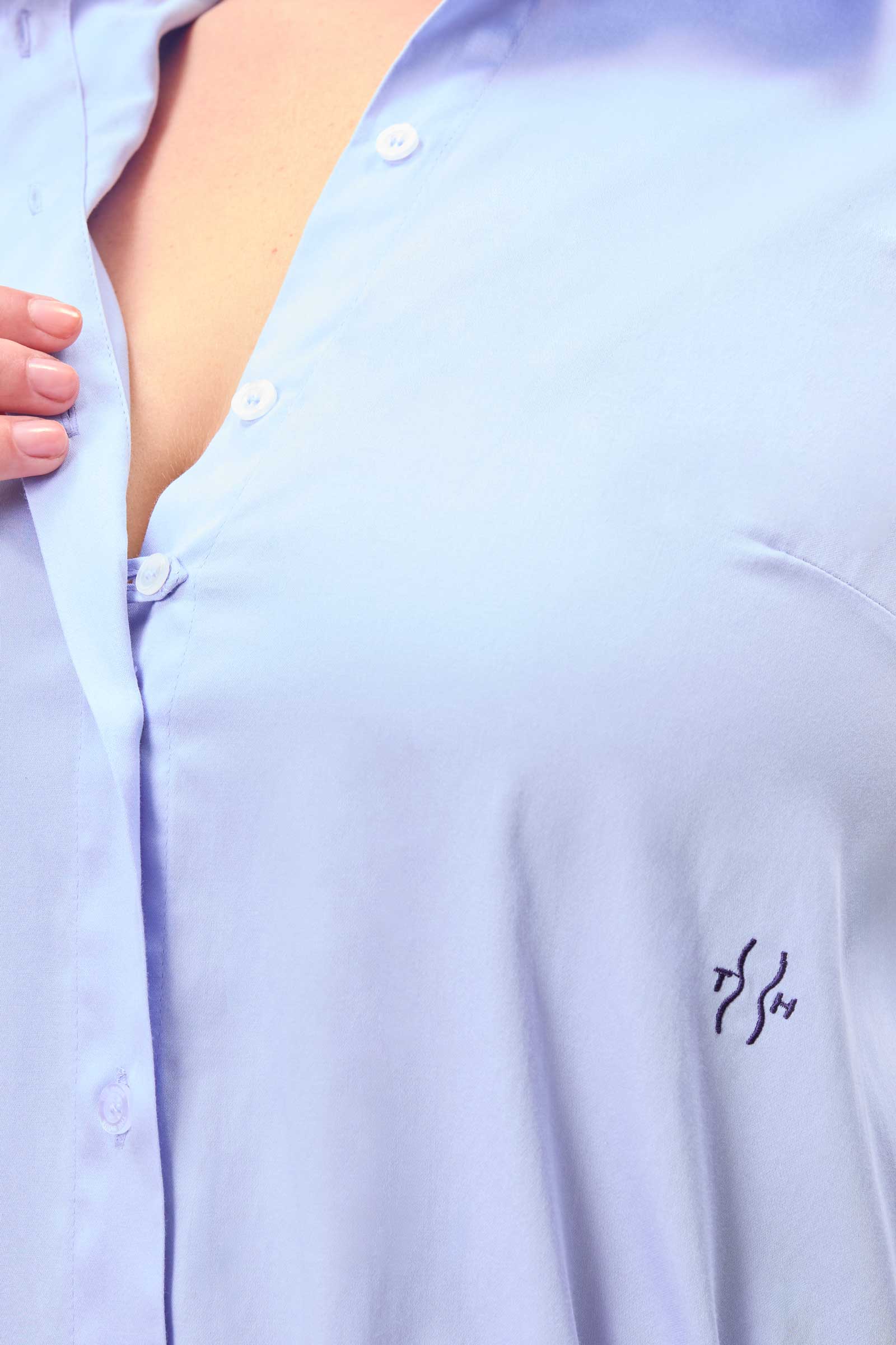 Detail of hidden placket and tonal embroidered logo on blue cotton sateen shirt – bust-friendly no-gape design