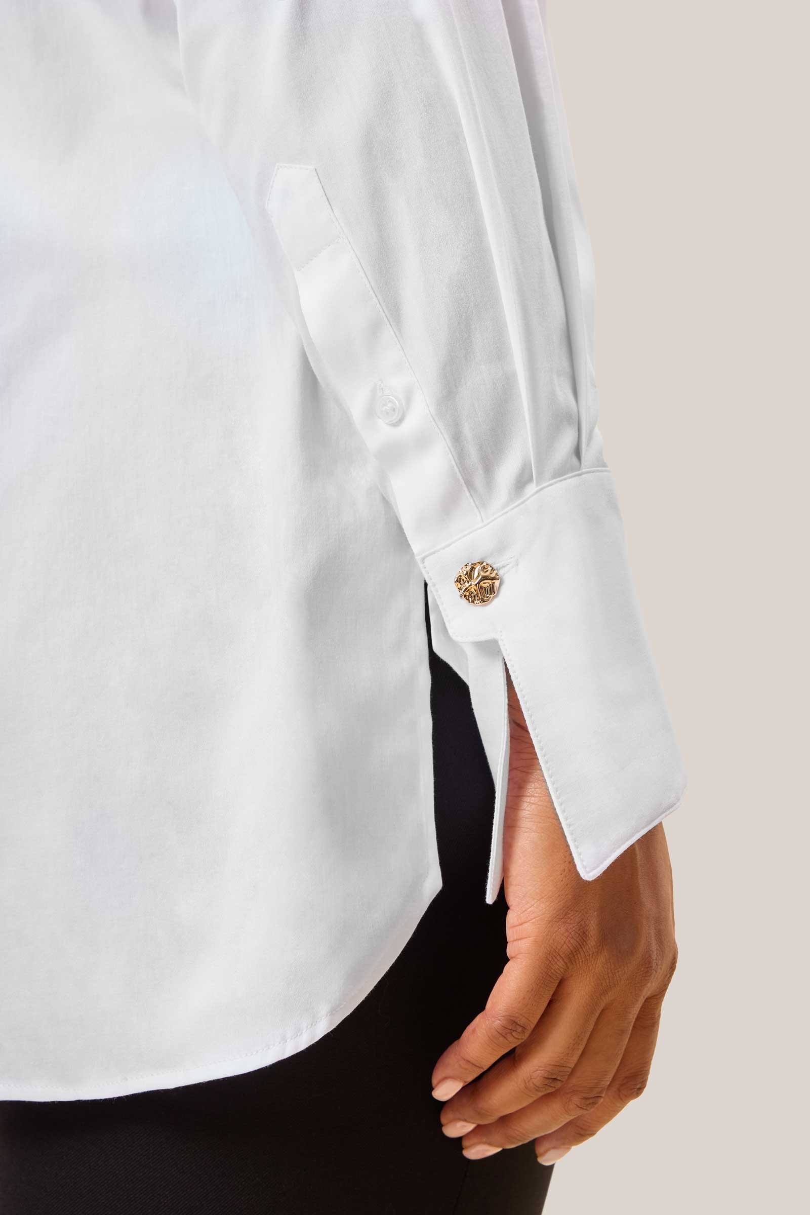 Close-up of gold cuff button on Italian cotton shirt for curvy women – soft sheen fabric texture