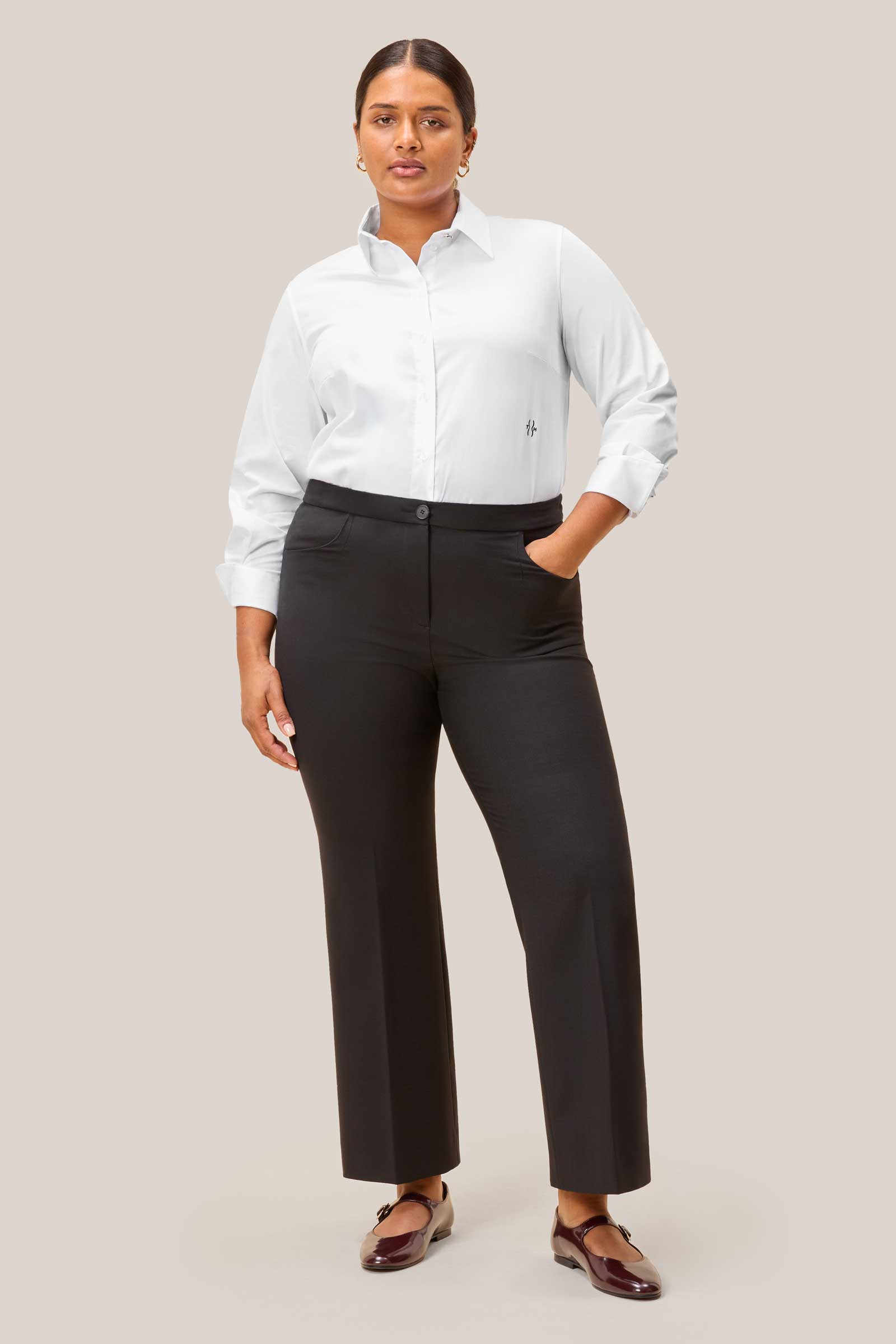 Curvy model wearing white cotton shirt & black trousers – front view, designed by The Hour
