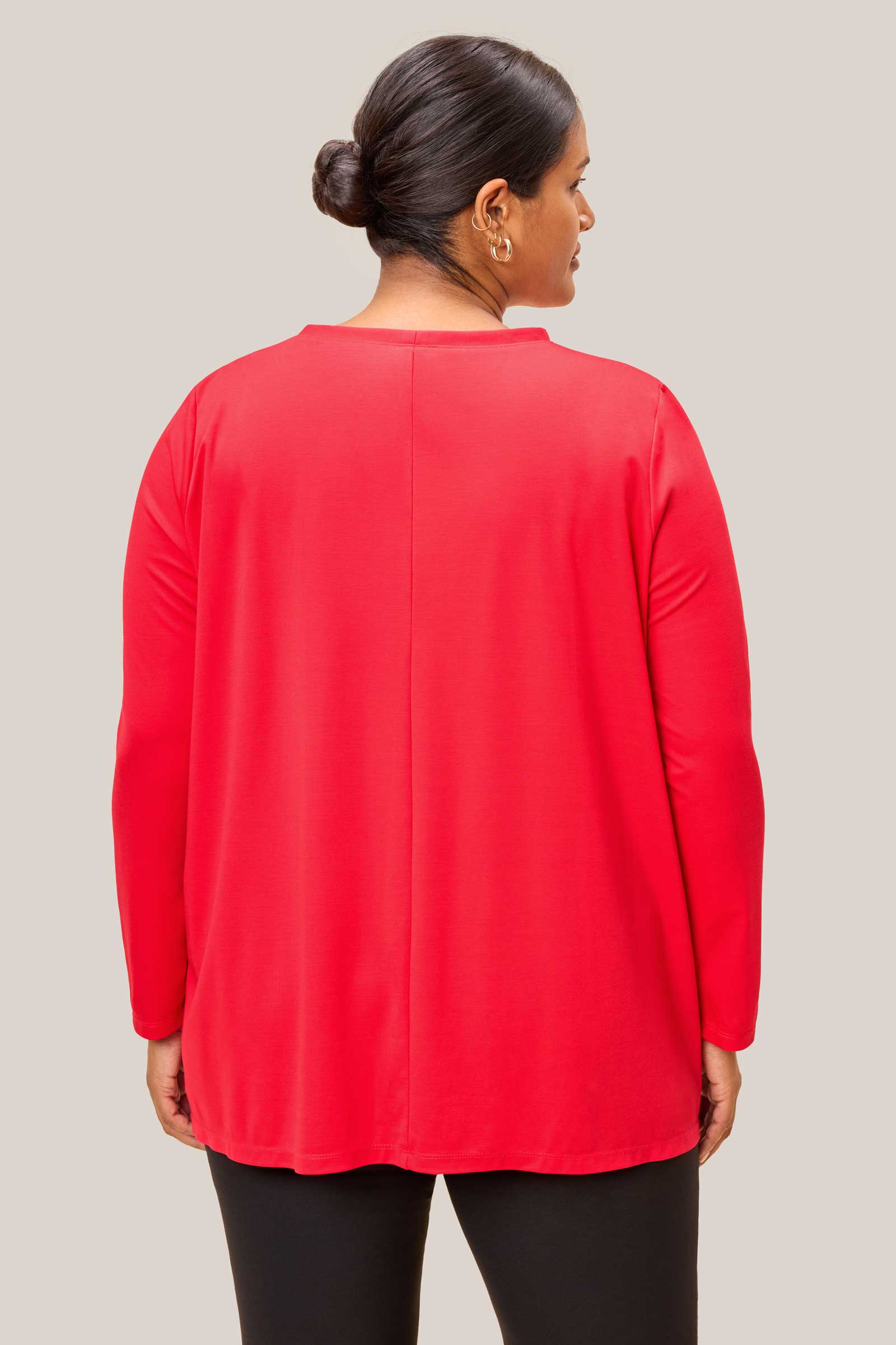 Back view of plus size red top showing dipped hem and relaxed fit. THE HOUR