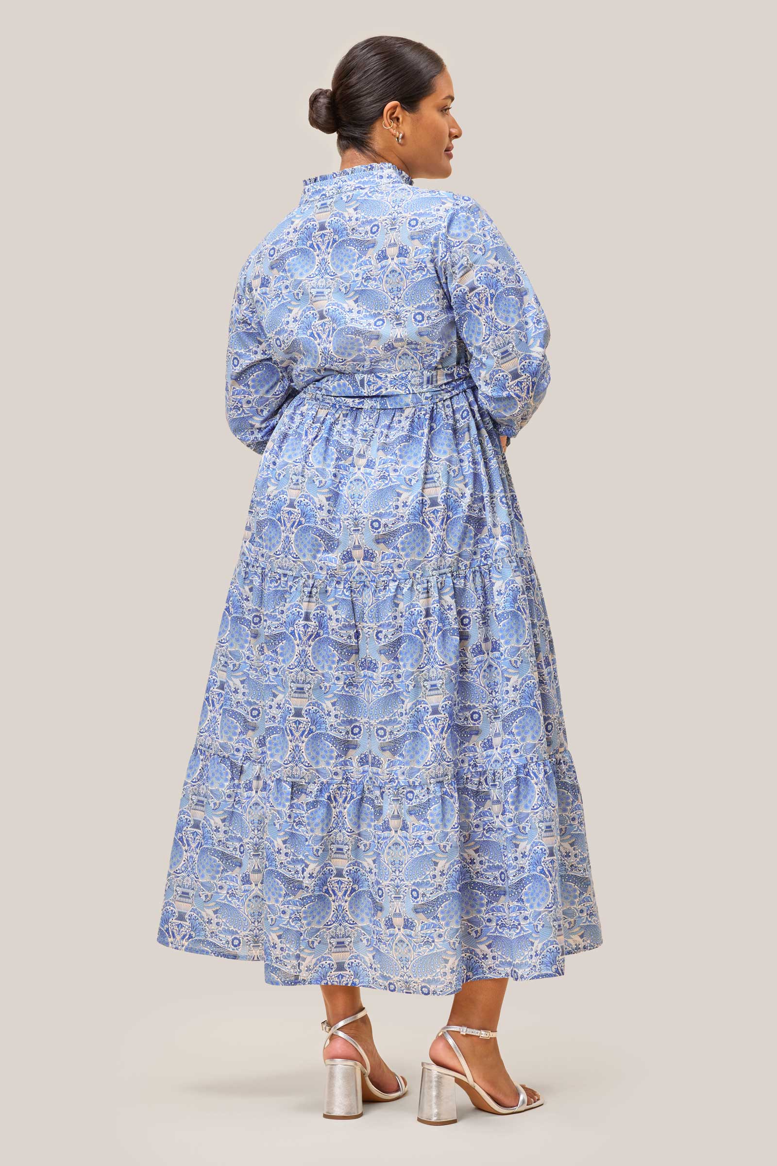 Back view of Oscars Palace Liberty Print Cotton Tiered Maxi Dress – plus size model wearing blue peacock print dress