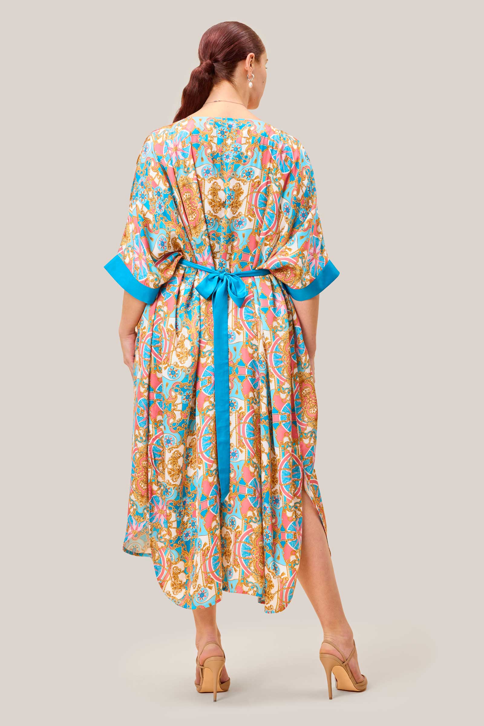 Back view of plussize model in printed satin kaftan with baroque design. THE HOUR