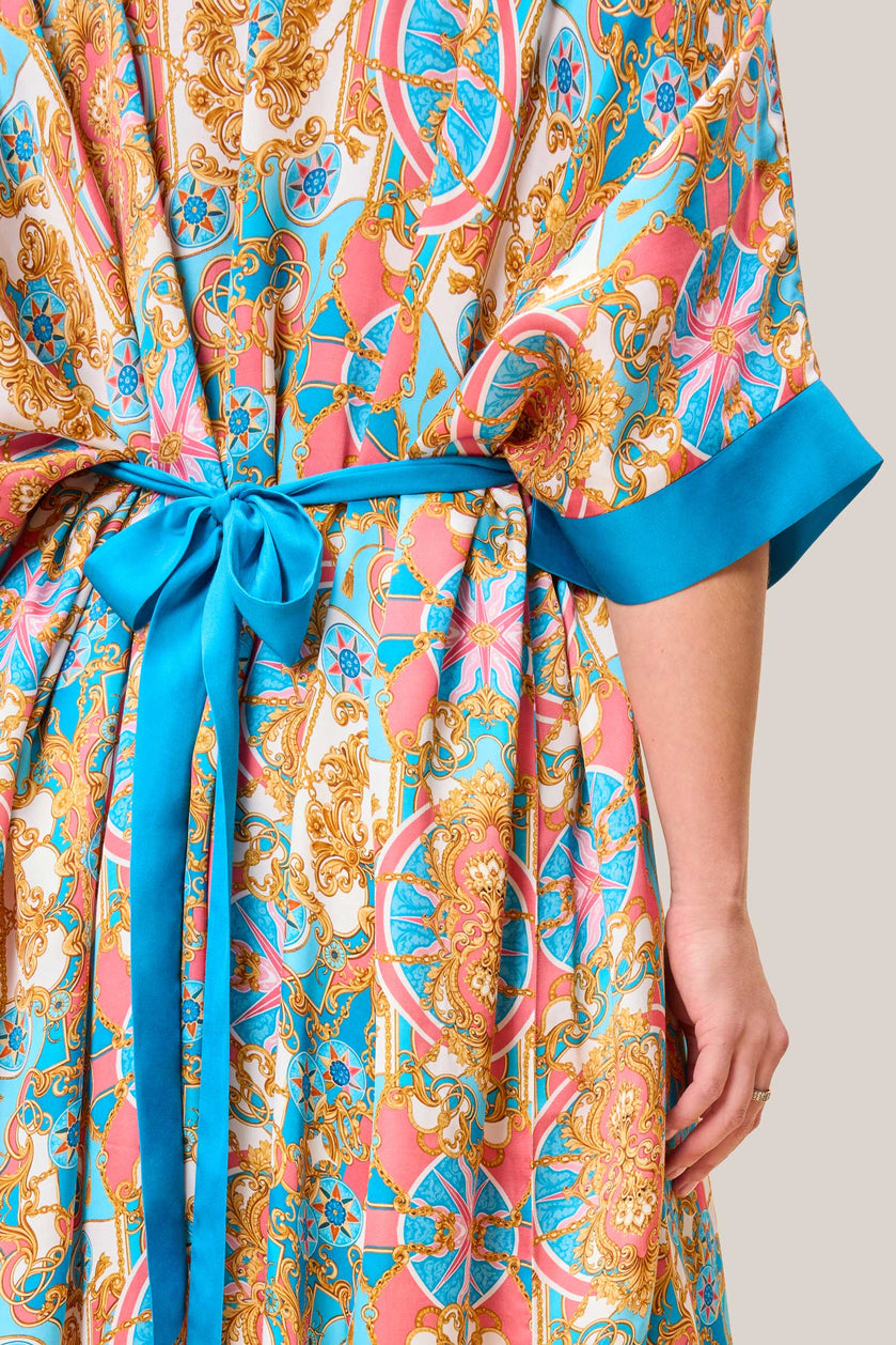 Close-up of BAROQUE printed satin kaftan fabric and turquoise belt detail. THE HOUR SIZE 10-28