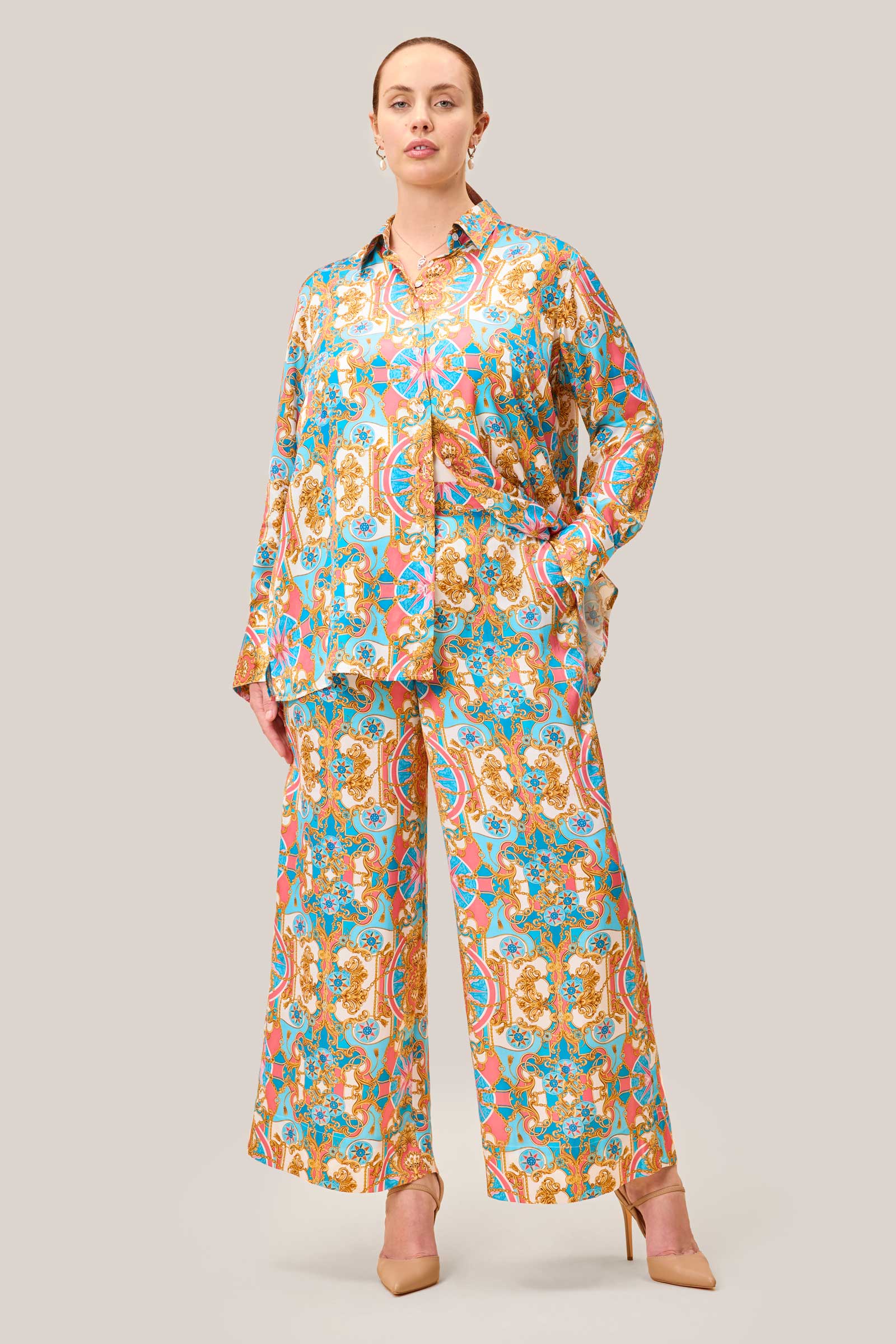 Plus size satin co-ord set with baroque print, featuring wide leg palazzo trousers and oversized shirt, styled elegantly with gold jewellery. THE HOUR