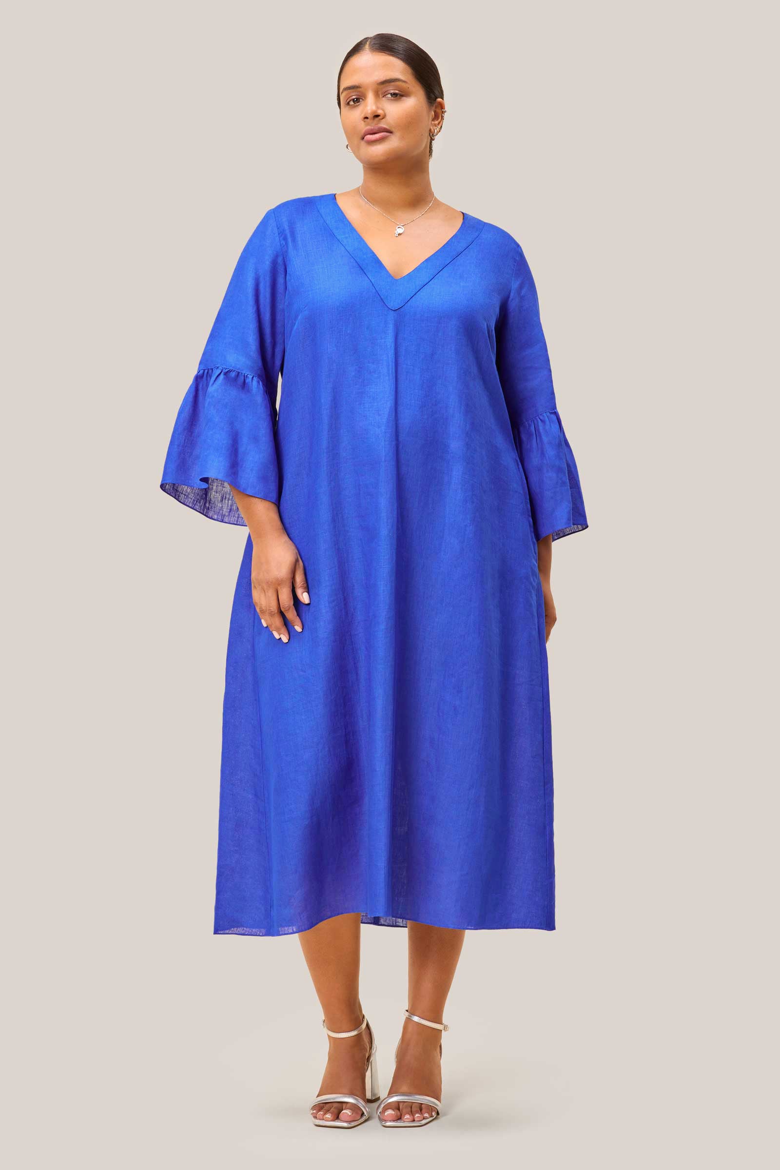 Plus size woman in royal blue linen A-line dress styled without tie belt