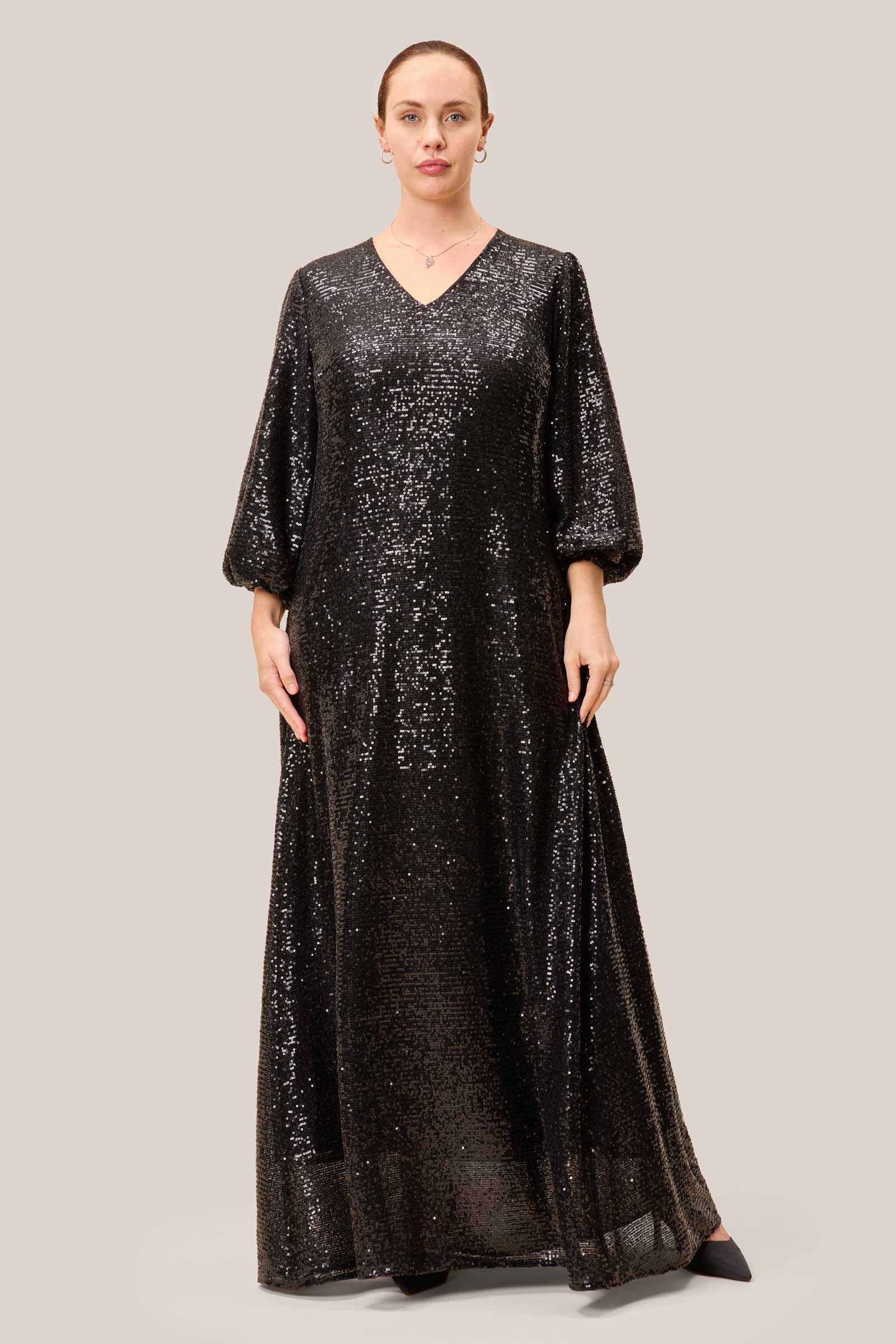 Plus-size model in a black sequin maxi dress with a V-neck and relaxed fit, ideal for evening occasions.