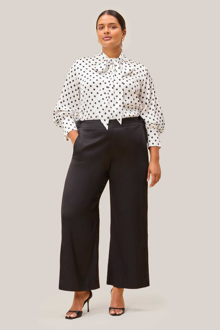 Full outfit: bow tie white satin polka dot blouse styled with black satin palazzo trousers. THE HOUR