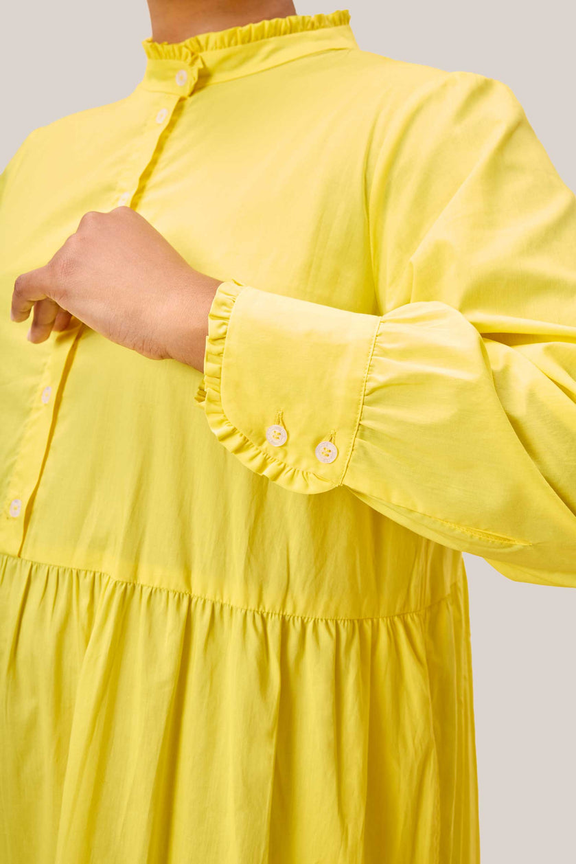 Close-up of high collar and button placket on yellow cotton dress