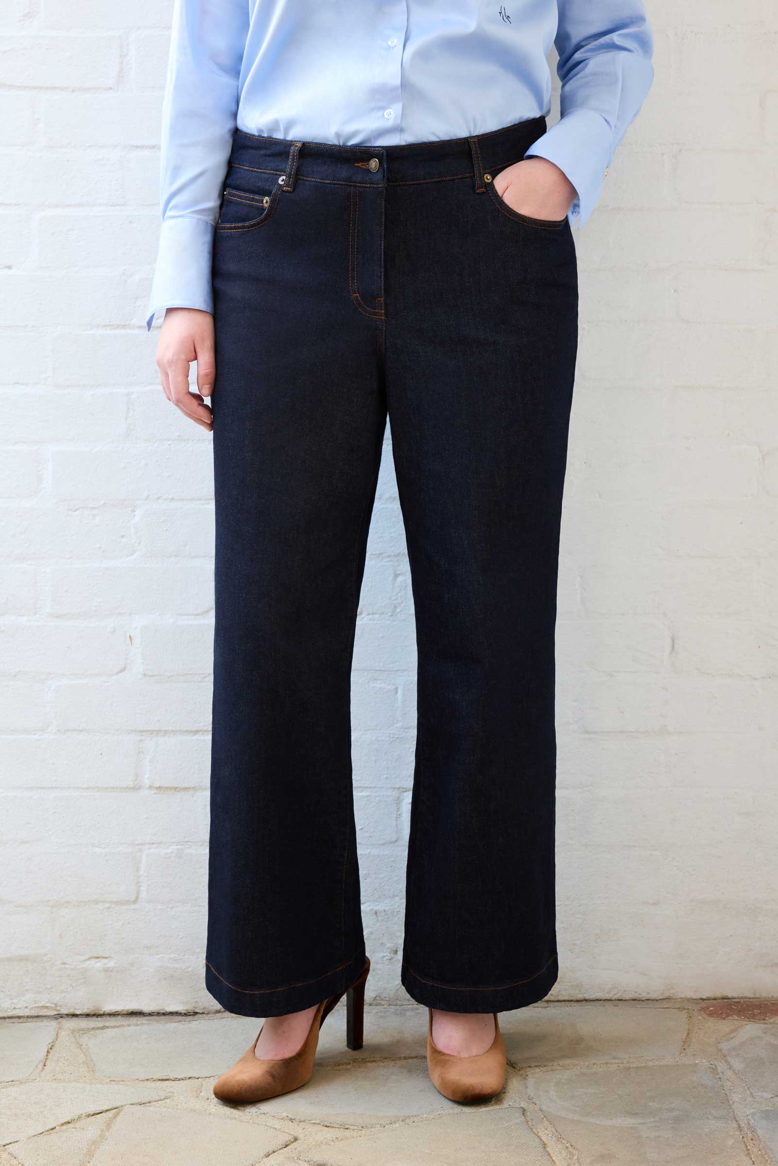 Plus size model wearing high waisted wide leg jeans in dark indigo denim from The Hour – front view