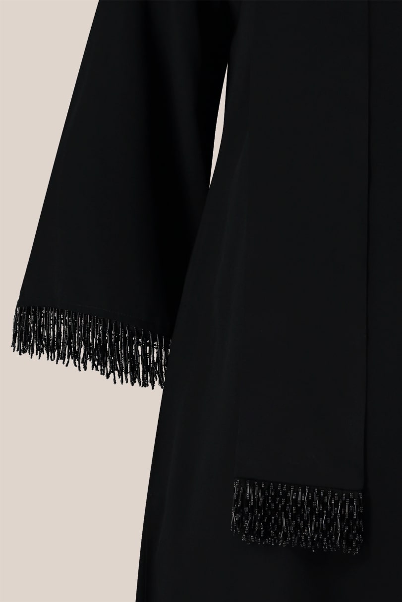 A-line black plus size maxi dress with wide sleeves decorated with a beaded fringe