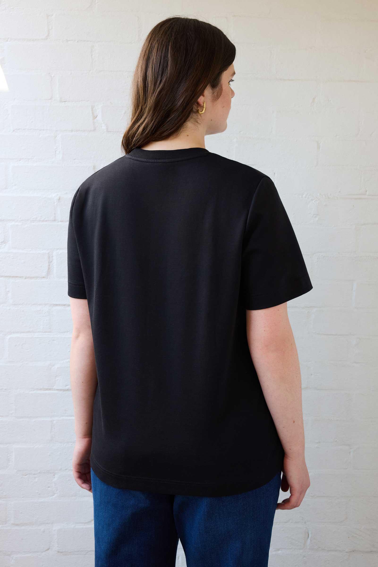 Back view of plus size organic cotton T-shirt in black, designed for curvy women by The Hour