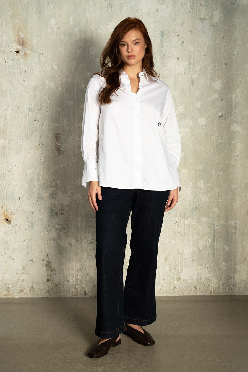 Curvy model wearing white cotton shirt and dark jeans – front view, designed by The Hour