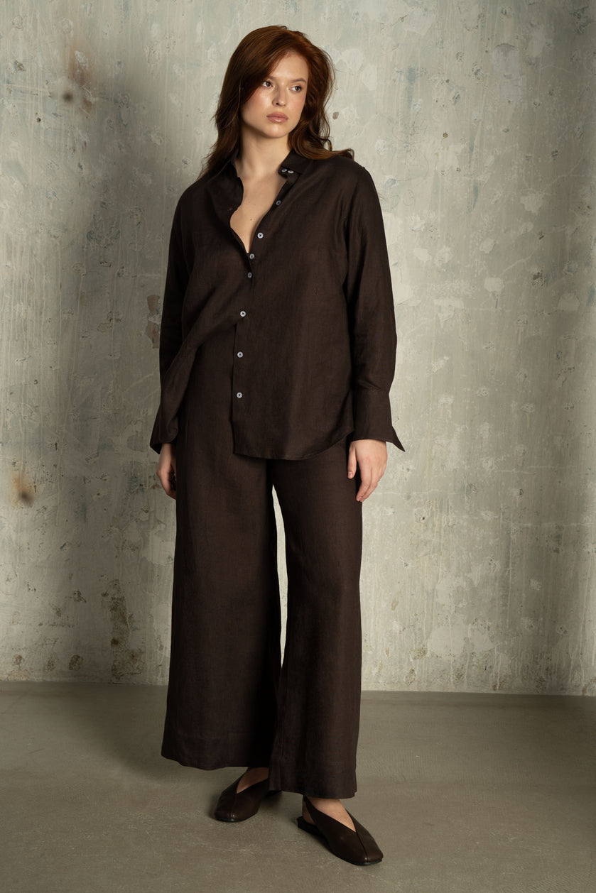 Model wearing THE HOUR Chocolate Brown Linen Shirt styled with matching black wide-leg linen trousers.