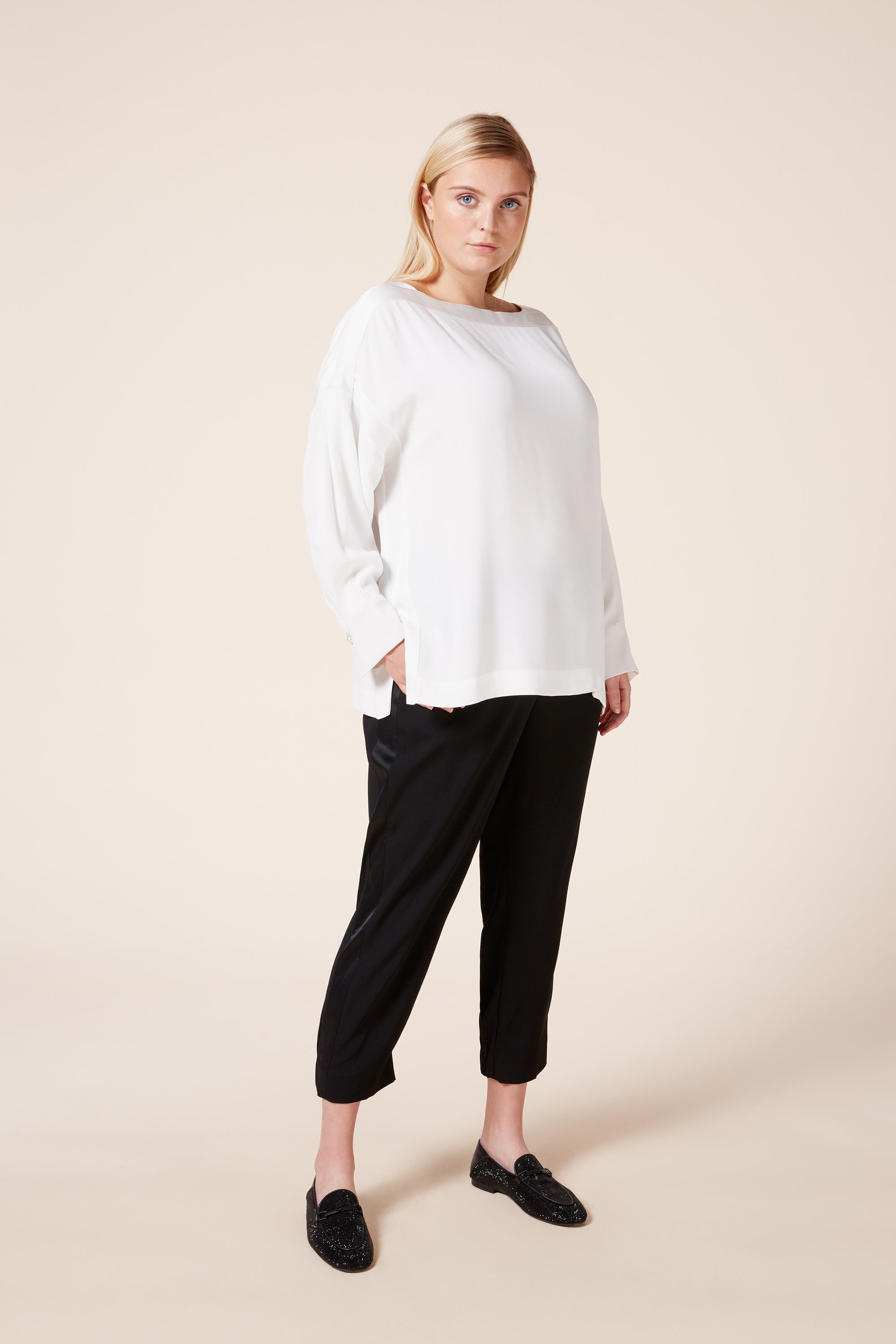 designer plus size boat-neck crepe tunic top features drop shoulders satin side panels and a pearl buttoned cuff